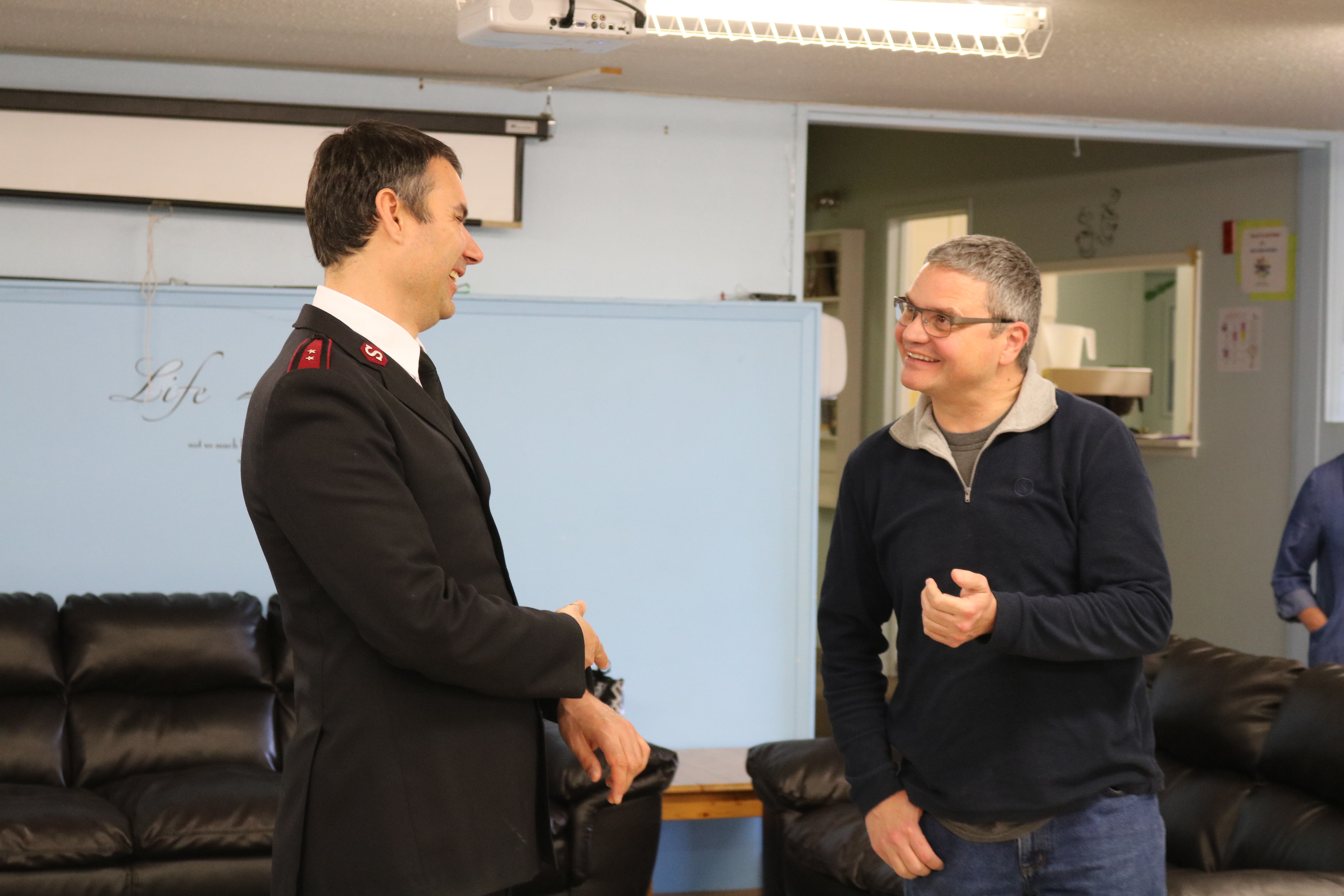 The Salvation Army officer speaking with a community member indoors.