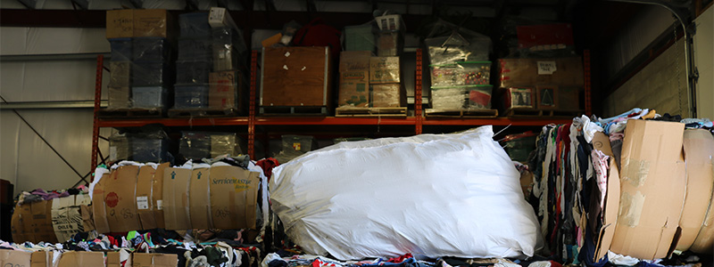 Interior of The Salvation Army Island Recycling Centre showing large bundles of sorted recyclable materials stored inside the facility.
