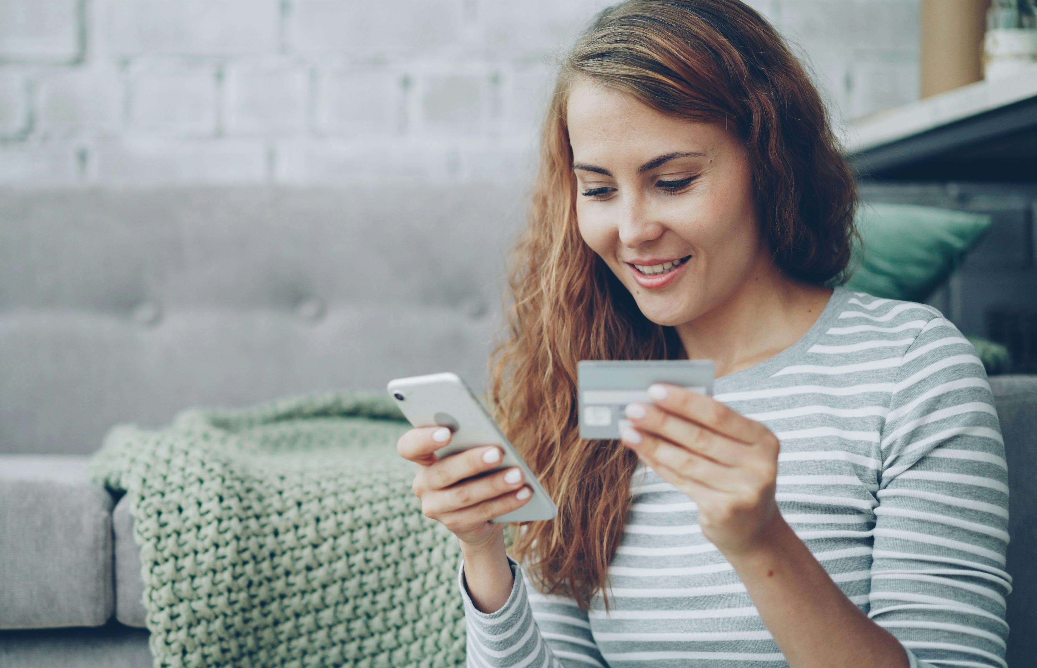 Person using a smartphone and credit card to make an online donation.