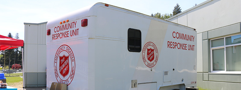 The Salvation Army Community Response Unit trailer parked outside a building, used to support emergency and disaster response services.