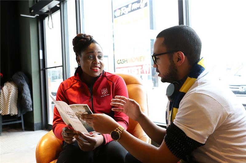The Salvation Army staff member meeting one-on-one with a community member, reviewing information and discussing support services in a welcoming setting.